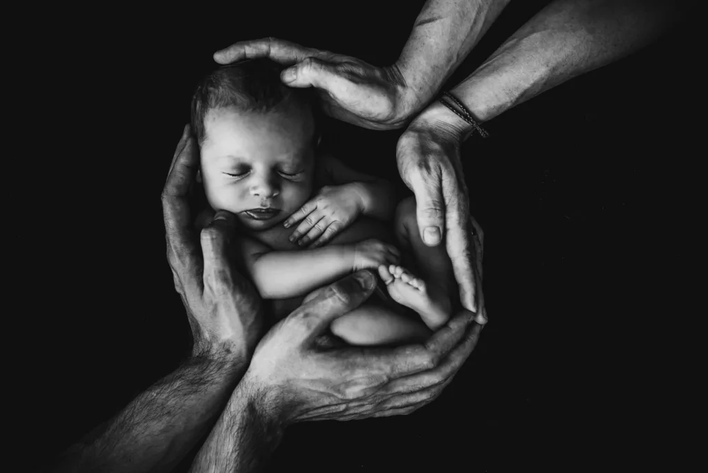 Baby wrapped in parents' hands