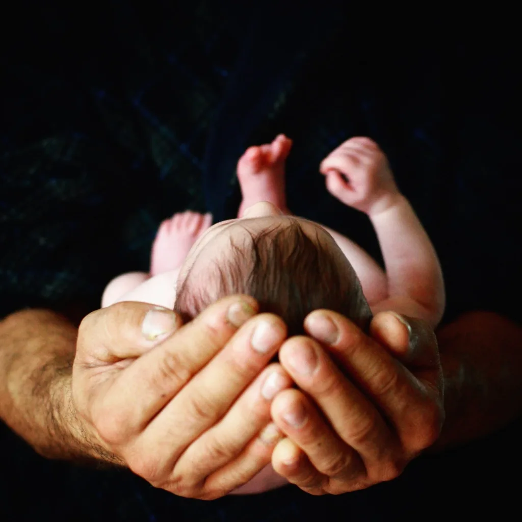 Baby wrapped in parents' hands